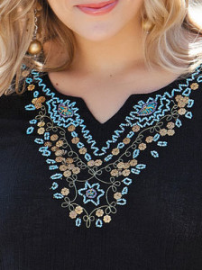 Turquoise beads on a black gauze tunic.